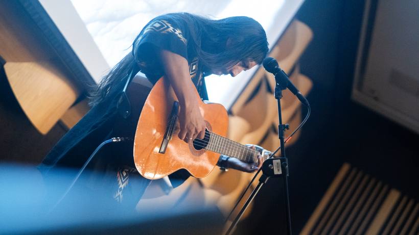 Músico tocando guitarra en el escenario